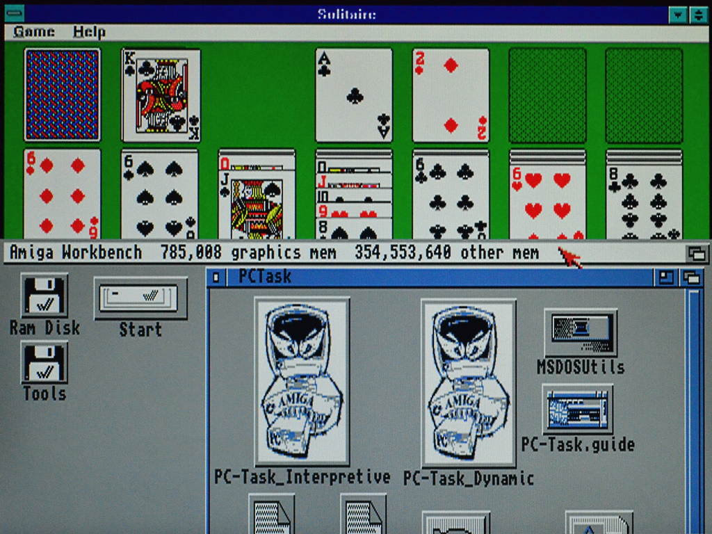 Screenshot showing Windows Solitaire in the top half and the Amiga Workbench screen in the bottom half.